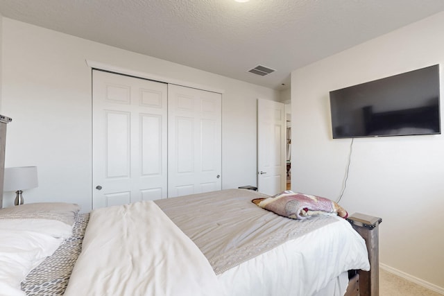 bedroom featuring carpet floors, a closet, and a textured ceiling