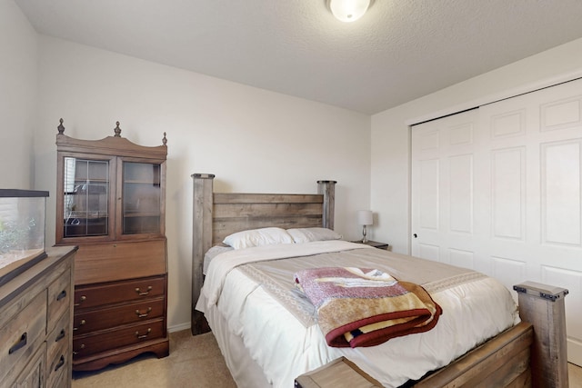 bedroom with light colored carpet, a closet, and a textured ceiling