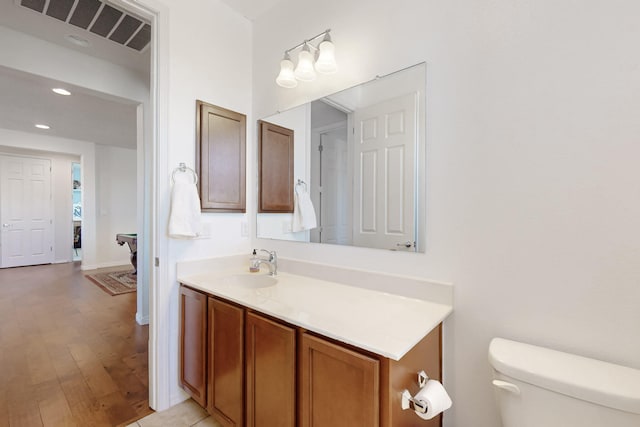 bathroom featuring hardwood / wood-style flooring, vanity, and toilet