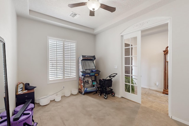 misc room featuring a textured ceiling, light colored carpet, and ceiling fan