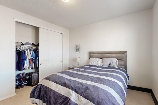 bedroom featuring light carpet, a textured ceiling, and a closet