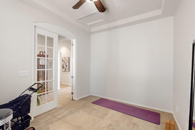 interior space featuring french doors, light colored carpet, and a raised ceiling