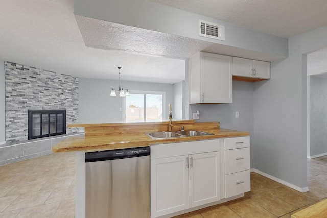 kitchen with wood counters, white cabinets, pendant lighting, and dishwasher