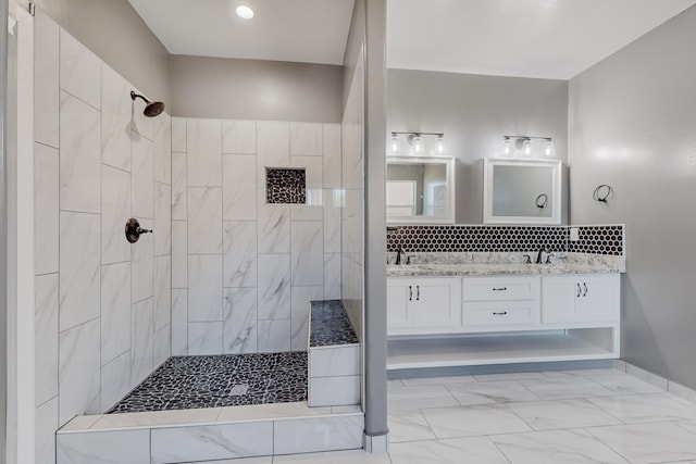 bathroom featuring a tile shower and vanity