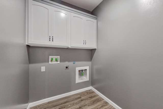 washroom featuring hookup for a washing machine, light wood-type flooring, cabinets, and electric dryer hookup