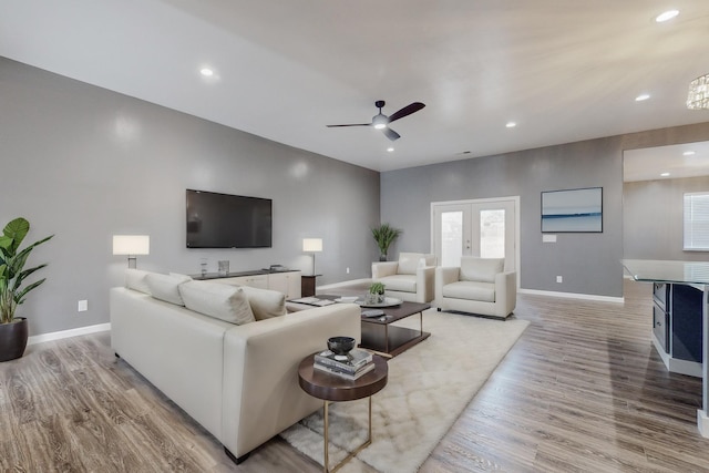 living room featuring light hardwood / wood-style flooring, ceiling fan, and french doors