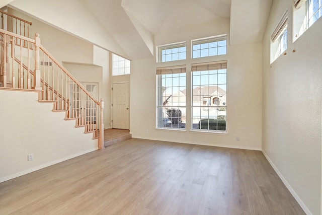 unfurnished living room featuring hardwood / wood-style floors and a high ceiling