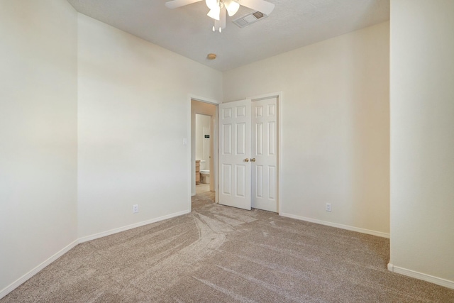 empty room with ceiling fan and light carpet