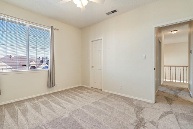 carpeted empty room featuring ceiling fan