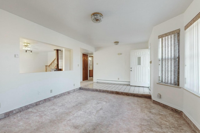 unfurnished room featuring baseboard heating and light carpet