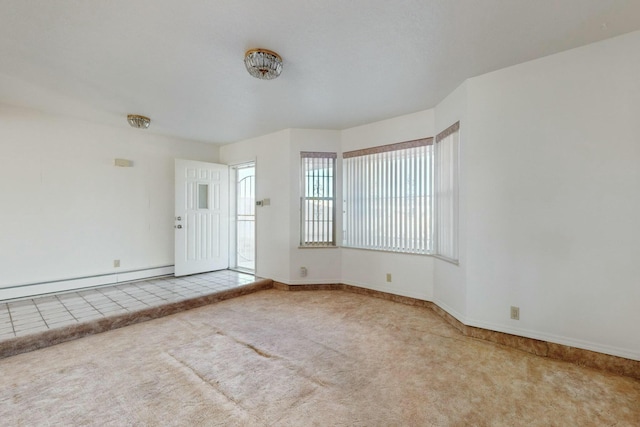 carpeted spare room with a baseboard radiator