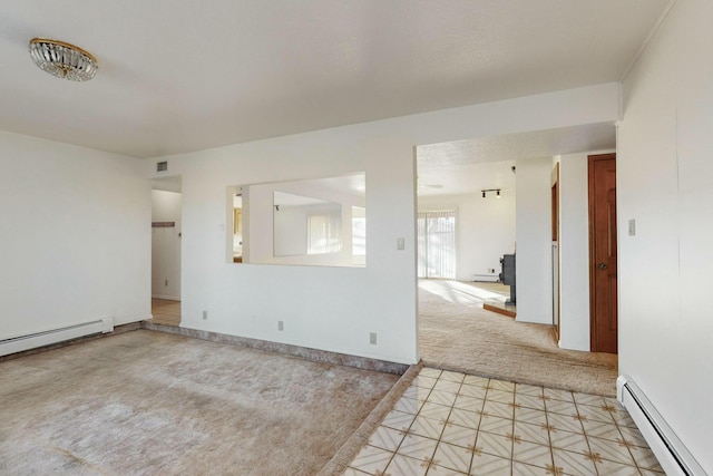 empty room featuring baseboard heating and light carpet