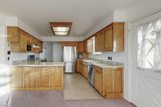 kitchen with stainless steel appliances, light tile patterned flooring, sink, and kitchen peninsula