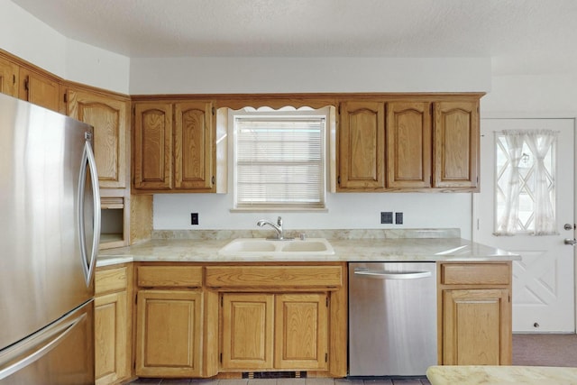 kitchen with sink, a textured ceiling, and appliances with stainless steel finishes