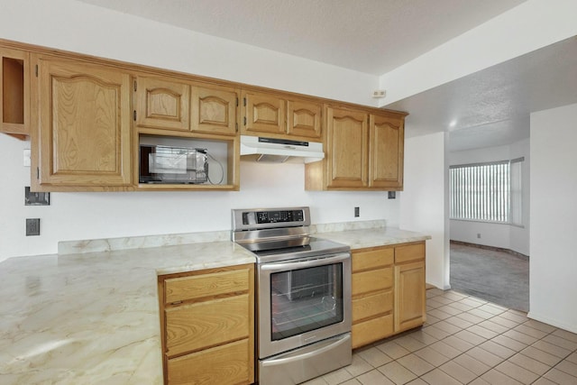 kitchen featuring light tile patterned floors, electric range, and a textured ceiling