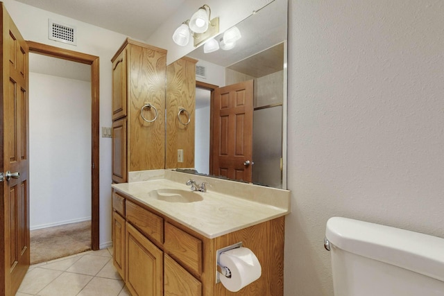 bathroom with tile patterned flooring, vanity, and toilet