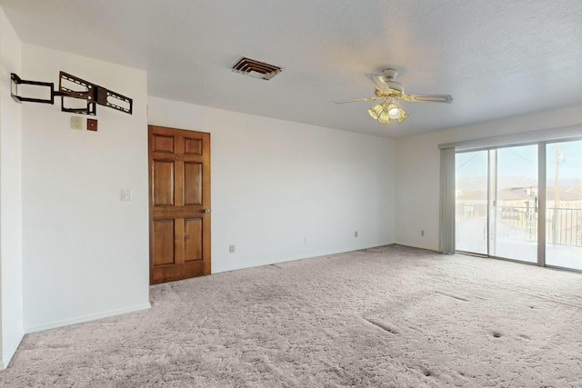 empty room with ceiling fan, carpet, and a textured ceiling