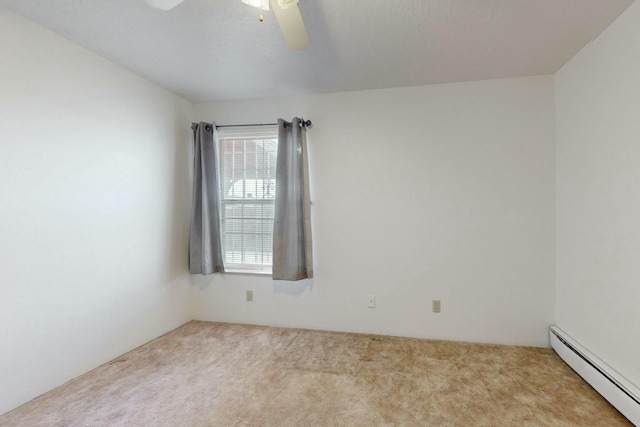 spare room featuring ceiling fan, light colored carpet, and a baseboard heating unit