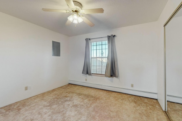 carpeted empty room with a baseboard heating unit, a textured ceiling, electric panel, and ceiling fan