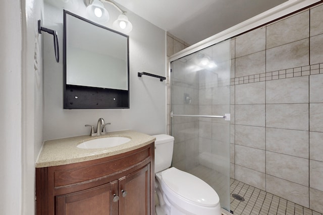 bathroom with vanity, a shower with shower door, and toilet