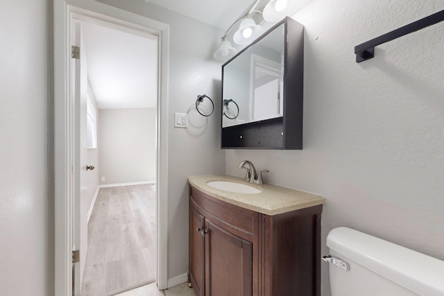 bathroom featuring vanity, toilet, and wood-type flooring