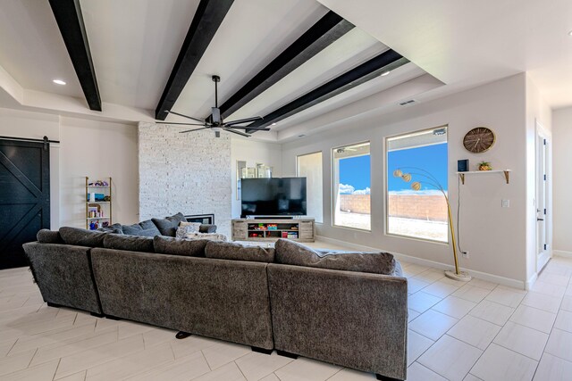 living room featuring beamed ceiling, a barn door, ceiling fan, and light tile patterned flooring