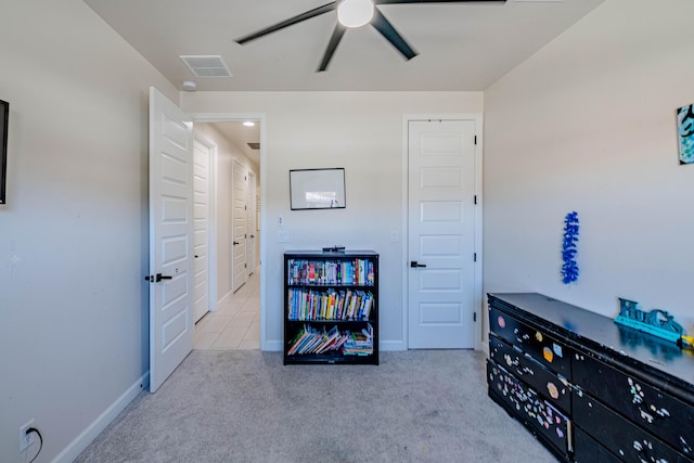 miscellaneous room with ceiling fan and light carpet