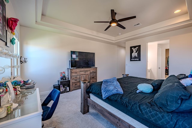 bedroom featuring ceiling fan, a raised ceiling, and carpet