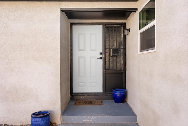 entrance to property featuring stucco siding