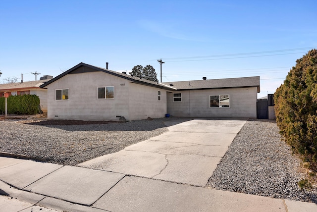 rear view of property featuring a patio area, fence, and stucco siding