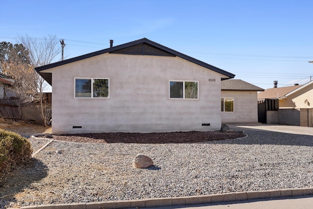 view of property exterior featuring a patio, crawl space, fence, and stucco siding