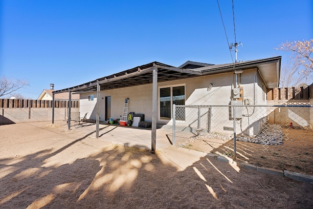 back of house with a patio area, a fenced backyard, and stucco siding