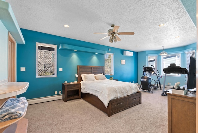 bedroom with a wall mounted air conditioner, a baseboard heating unit, light colored carpet, ceiling fan, and a textured ceiling