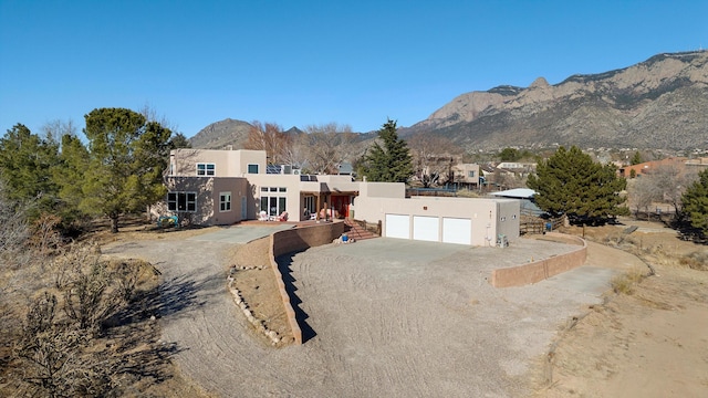 view of front of home with a garage and a mountain view