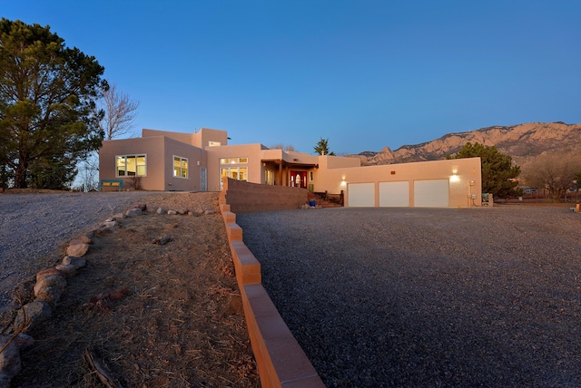 adobe home featuring a garage and a mountain view