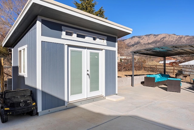 view of outdoor structure featuring a mountain view, outdoor lounge area, and french doors