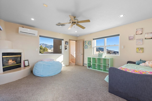 bedroom featuring ceiling fan, a wall mounted AC, and carpet floors