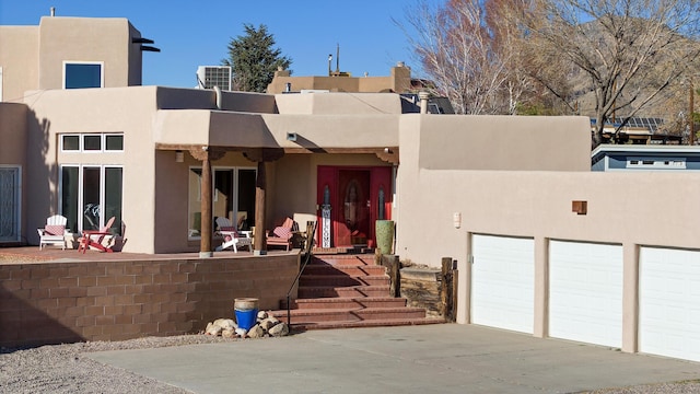 view of front of house with a garage and central AC unit