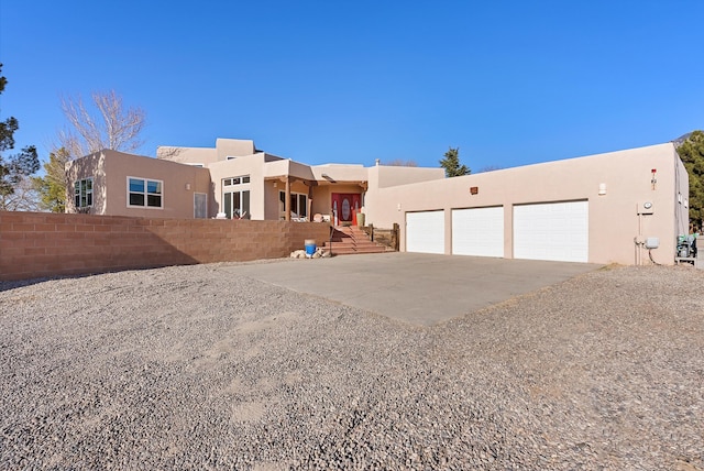 pueblo revival-style home with a garage