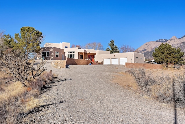 pueblo-style house with a mountain view and a garage