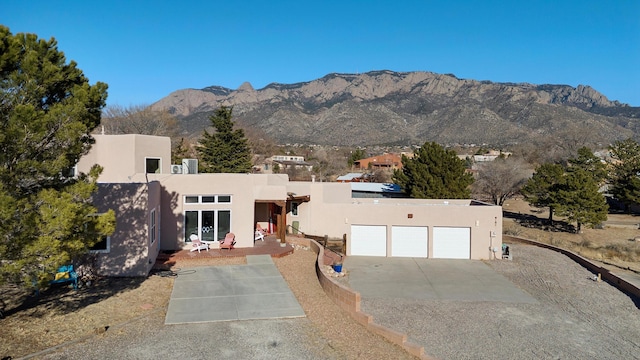 view of front facade featuring a garage, a patio, and a mountain view