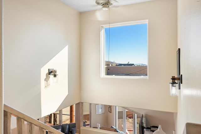 stairs featuring ceiling fan