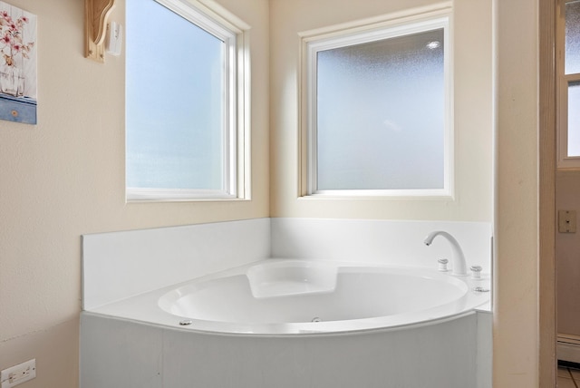 bathroom with a baseboard radiator and a bath