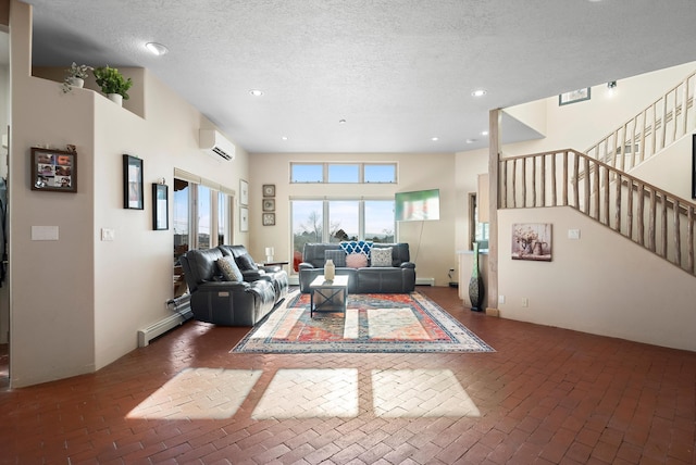 living room featuring baseboard heating, a wall mounted air conditioner, and a textured ceiling