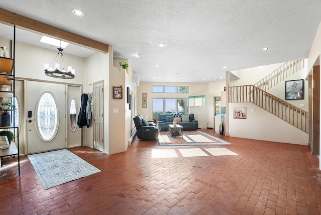 foyer with a textured ceiling and a notable chandelier