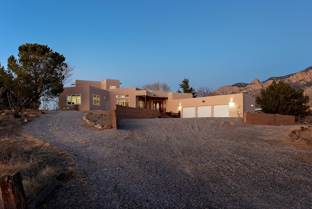 pueblo revival-style home with a mountain view and a garage