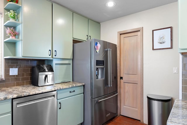 kitchen with decorative backsplash, stainless steel appliances, and green cabinetry