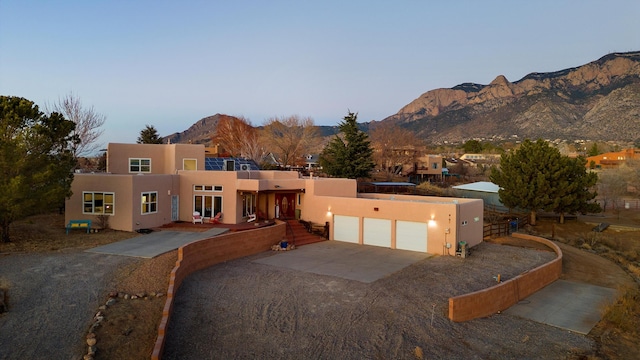 pueblo revival-style home with a mountain view and a garage