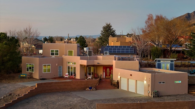 view of front facade featuring a mountain view and solar panels