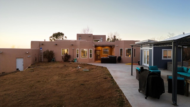 back house at dusk with a patio area and french doors